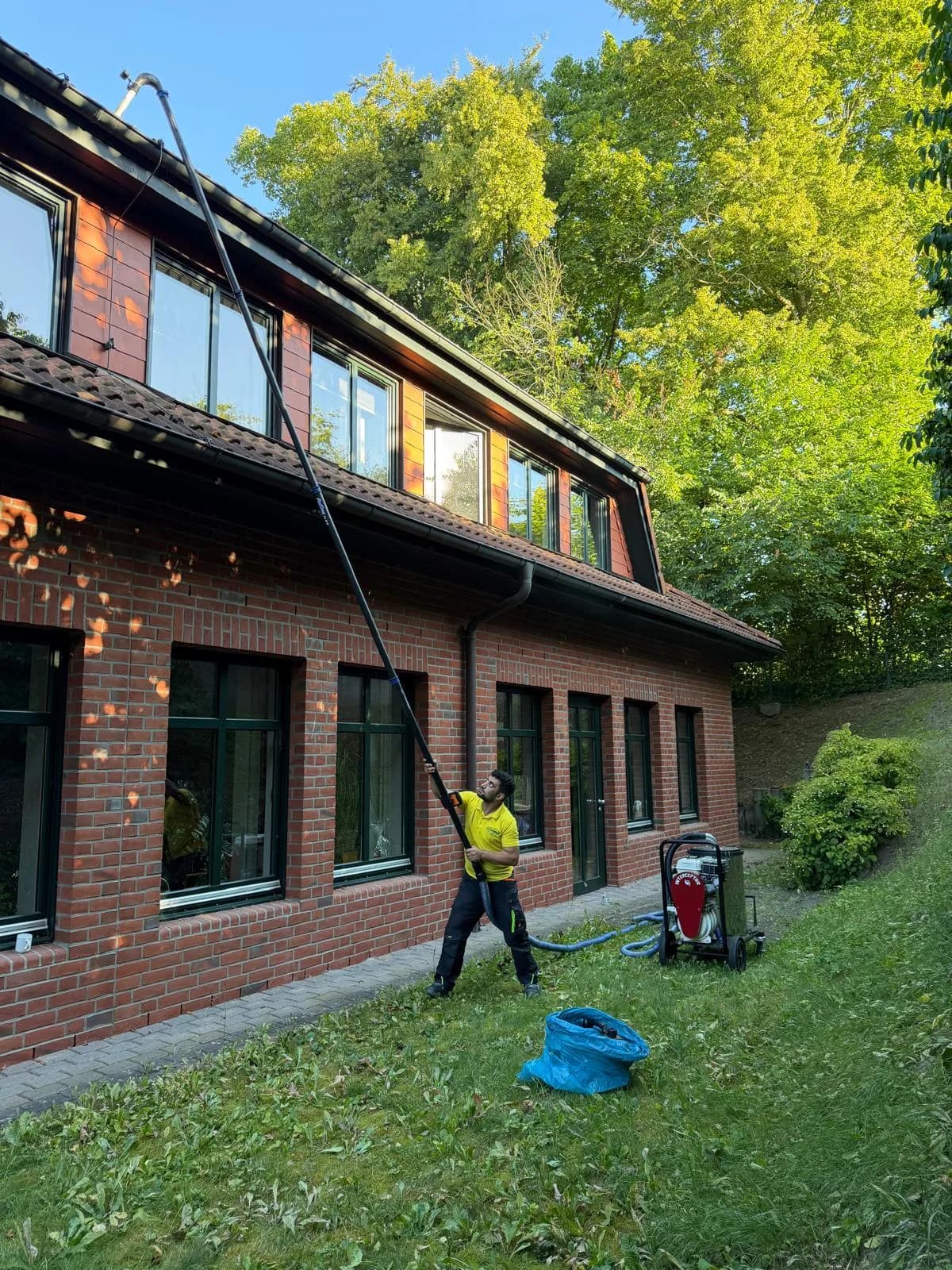 Dachrinnenreinigung am mehrgeschossigen Klinkergebäude – Blitz Gebäudereinigung im Einsatz