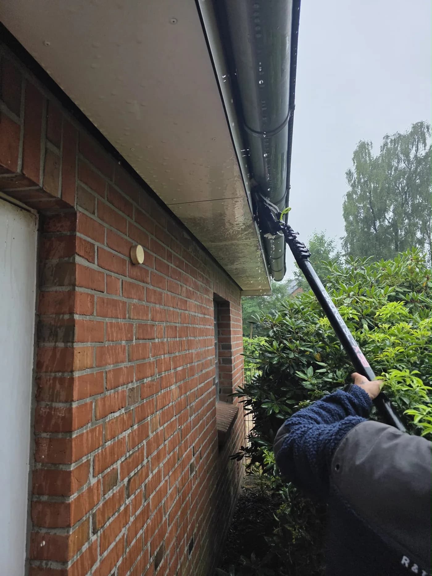 Arbeiten an einer Dachrinne – Blitz Gebäudereinigung im Einsatz